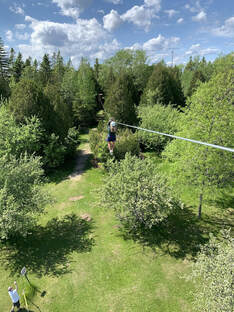 Woman zip lining into the trees