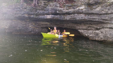 Three people kayaking in a a cave